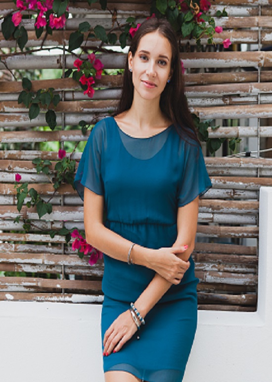 young stylish beautiful woman in blue dress, summer fashion trend, vacation, garden, tropical hotel terrace, smiling